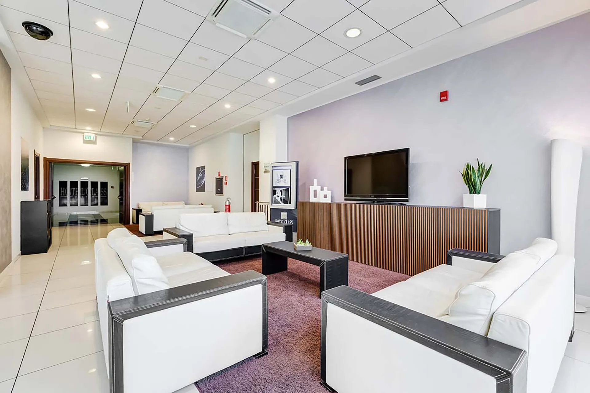 The image shows the lobby with the reception desk and an area with sofas.